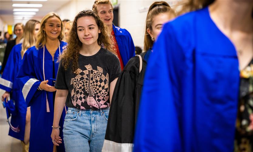 Graduating seniors walk down the hall